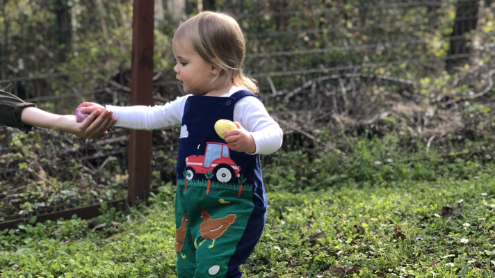 A child holding Easter eggs and an Easter basket with eggs.