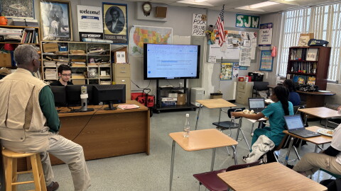 C.B. Hanif's classroom at Inlet Grove Community High School, where student reporters are combining their articles into one story. Hanif, left, offers nuggets of wisdom, like: "Editorial writing is the art of knowing what to leave out."