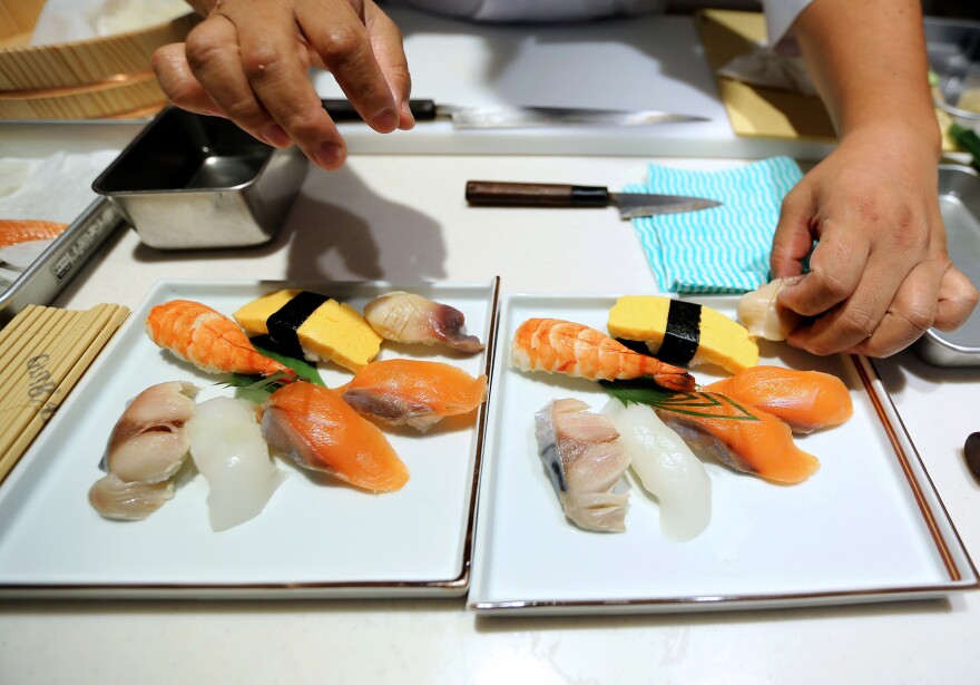 A sushi chef prepares a dish during the Global Sushi Challenge competition in Tokyo in September. Japan's new program will certify Japanese restaurants outside of the country that meet the standards of traditional Japanese food, known as <em>washoku.</em>