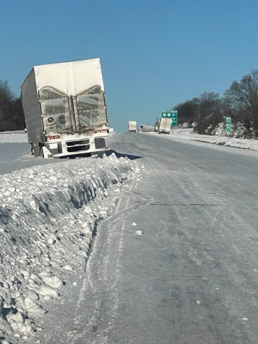 Image shows Semi-Trucks stalled on the side of the highway due to poor winter weather conditions.