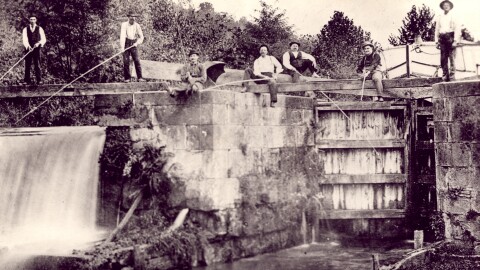 Men fishing at an unidentified lock on the Ohio & Erie Canal in Akron, Ohio, in 1890. A lock allows a canal boat to travel from one level of water to another level of water.