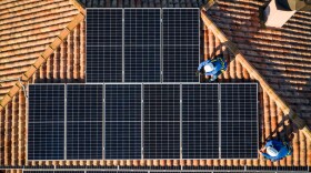 Aerial view of workers installing solar panels on a roof