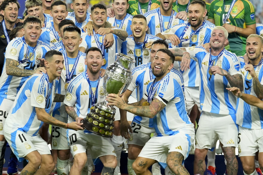 Argentina players Angel di Maria, left, Lionel Messi, second from left, and Nicolas Otamendi, third from left, celebrate with the trophy after defeating Colombia in the Copa America final soccer match in Miami Gardens, Fla., Monday, July 15, 2024.