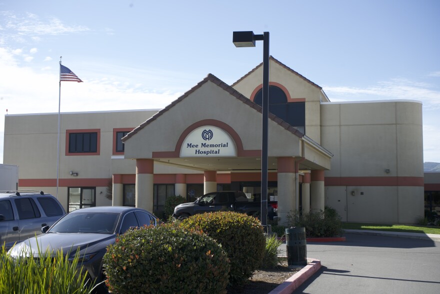 A hospital in South Monterey County, with the U.S flag on the left and cars parked outside.