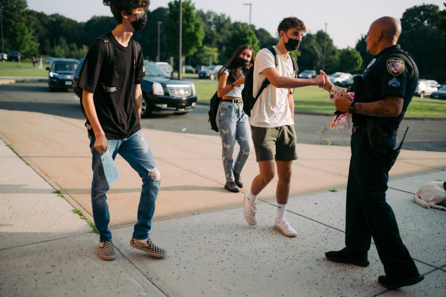 Students at Watertown High arrive for their first day back to school and greet officer Jeff Desena before walking in. Tony Spinelli/Connecticut Public