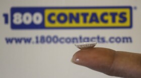 A contact lens is shown in front of a 1-800-Contacts shipping box Wednesday, May 13, 2015, in Salt Lake City. (Rick Bowmer/AP)