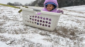 Aria Johnson, 1, enjoys snow in an improvised sled in Montgomery, Ala., Tuesday, Jan. 21, 2025. (AP Photo/Kim Chandler)