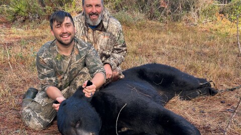 Jeff Nemeth, 57, and his son Rees Nemeth, 27, pose with an 8-foot-3-inch Florida black bear they harvested on Dec. 9, 2025, in Eastpoint, Fla. Jeff Nemeth traveled four hours north from his home in Inverness to hunt the bear, which he said weighed 503 pounds once cleaned.