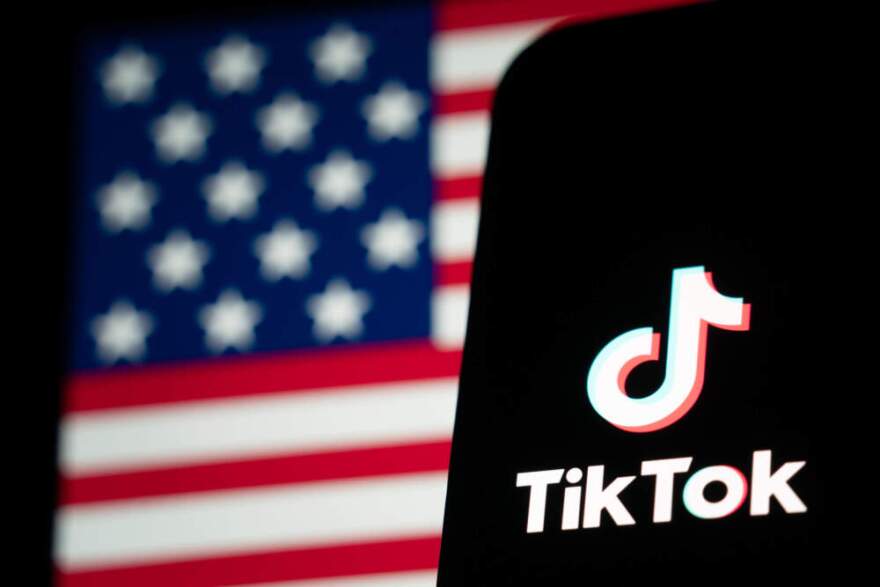 In this photo illustration, the TikTok logo and flag of the United States are seen on screens. (Anthony Kwan/Getty Images)