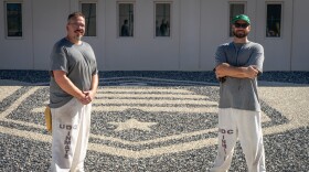 Ryan Parker and Alexander Wardell, inmates at the Utah State Correctional Facility in Salt Lake City, stand in front of gravel art recreating the state flag, Aug. 20, 2026.