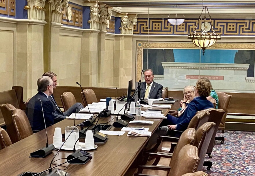 Oklahoma Treasurer Todd Russ, seen through a window, discusses options with attorneys during an executive session of the Tobacco Settlement Endowment Trust Board of Investors at the Capitol in Oklahoma City on Wednesday, July 1, 2026.