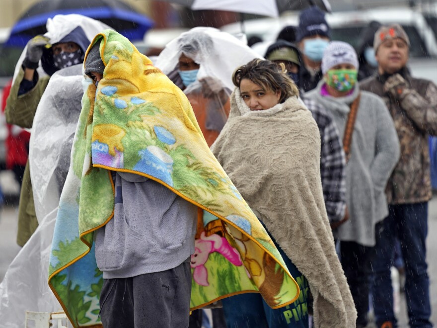 People wait in line to fill propane tanks on Feb. 17 in Houston. Power grid problems left millions weathering conditions in the dark in uninsulated homes, intensifying the Texas winter storm's deadliness.