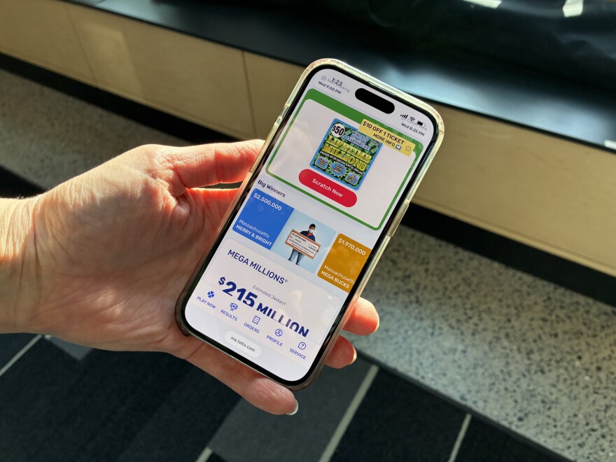 A hand holds a phone showing a digital lottery game.