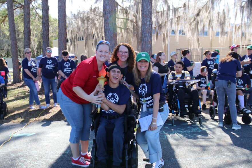 One of Hillcrest’s students smiles after completing his leg of the torch relay as he poses with Schank (left), Assistant Principal Cindy Lowe (middle) and Principal Lori Manresa (right) on Thursday, March 5, 2026. Schank said one senior is selected from each of Hillcrest’s eight programs to participate in the opening-ceremony torch run.