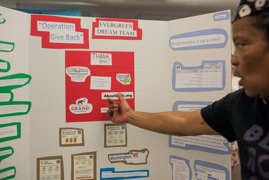 Shari Douglass explains her homelessness resources project at the Spring Fair. Douglass and her team created resource kits, which they distributed to Tacoma's homeless population.