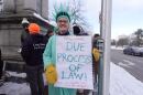 Jennifer Wriggins, a retired law professor at U Maine School of Law, holds a sign as she protests ICE in Portland.