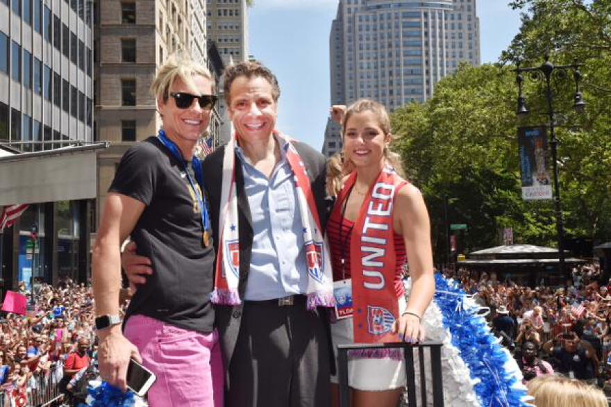 Abby Wambach with Governor Cuomo and his daughter aboard a float at today's parade