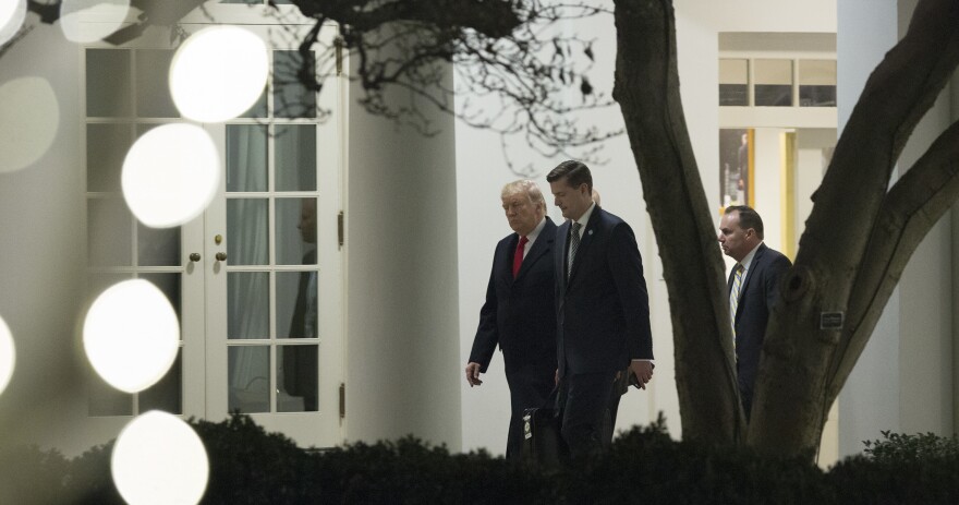 President Trump speaks with White House secretary Rob Porter (center) and Sen. Mike Lee, R-Utah, outside the White House in December. Porter resigned this week amid allegations of domestic violence against his ex-wives.