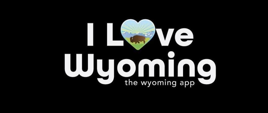 "I Love Wyoming" is written in large white letters. The "O" in "Love" is actually a heart with a cartoon drawing of a bison in front of a mountain range and a sunset. Under those words, smaller, says "the Wyoming app"