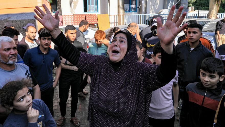 A woman reacts as people gather at the site of Al Ahli Arab hospital in central Gaza on Wednesday in the aftermath of an overnight explosion there.