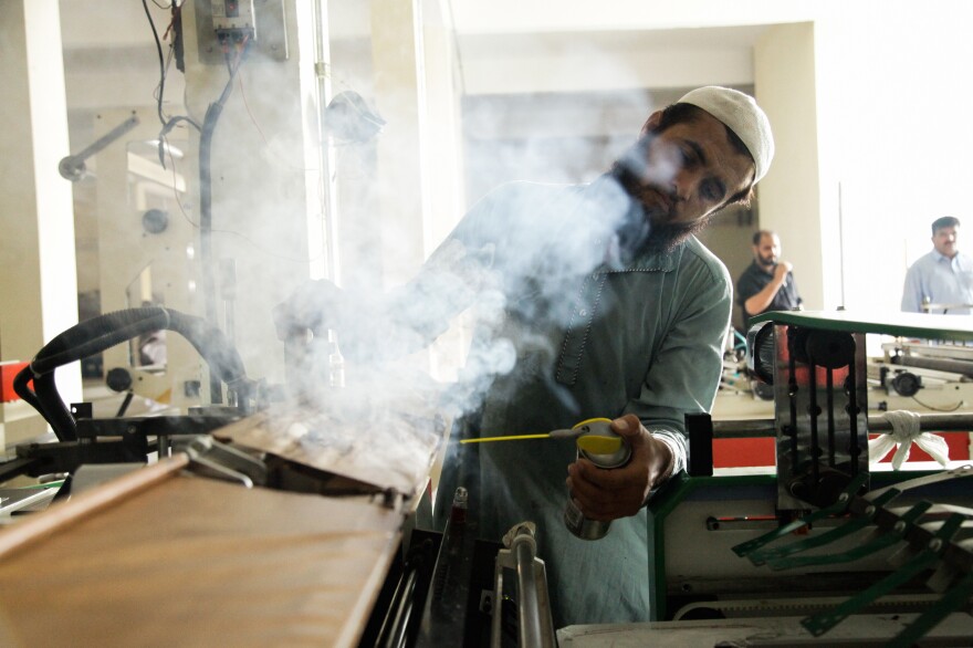 A worker operates a machine at a plastic bag factory on the outskirts of Islamabad.