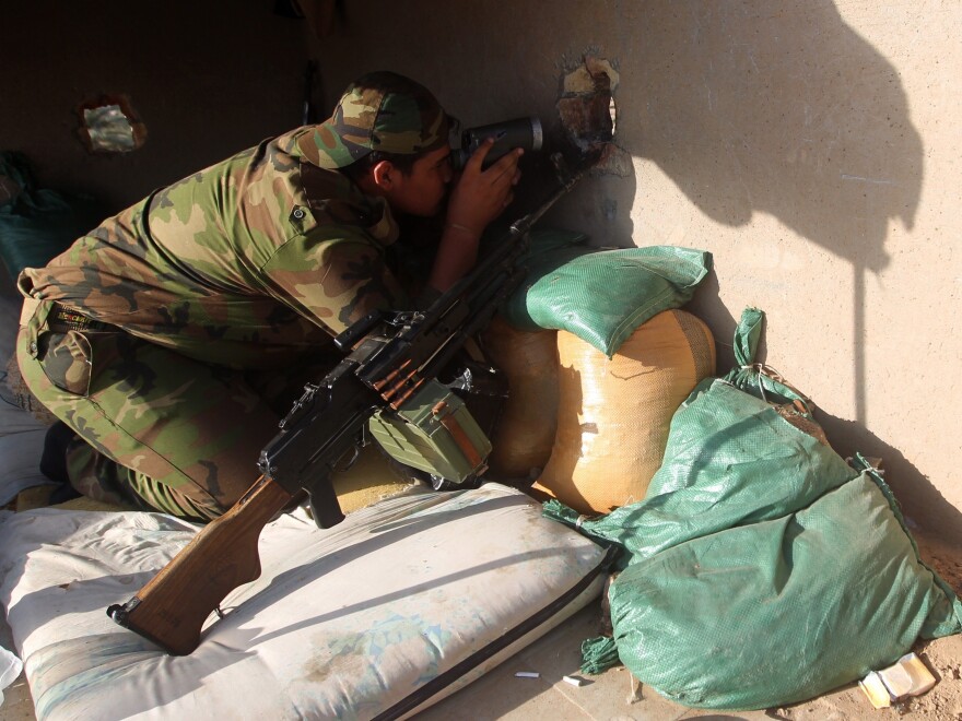 An Iraqi Sunni fighter holds a position during clashes with Islamic State group fighters in October the town of Dhuluiyah.