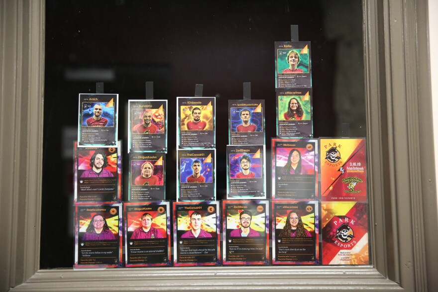 Trading cards of Park University's esports athletes hang in an office window.