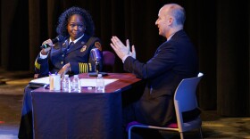 Lansing Fire Chief Carrie Edwards-Clemons, left, speaks during Lansing Mayor Andy Schor's State of the City Address at Dart Auditorium in Lansing, Mich., on March 18, 2026. Rather than giving a traditional speech, Schor, right, sat behind a talk show style desk and invited city staff to provide updates on their departments' achievements from the past year.