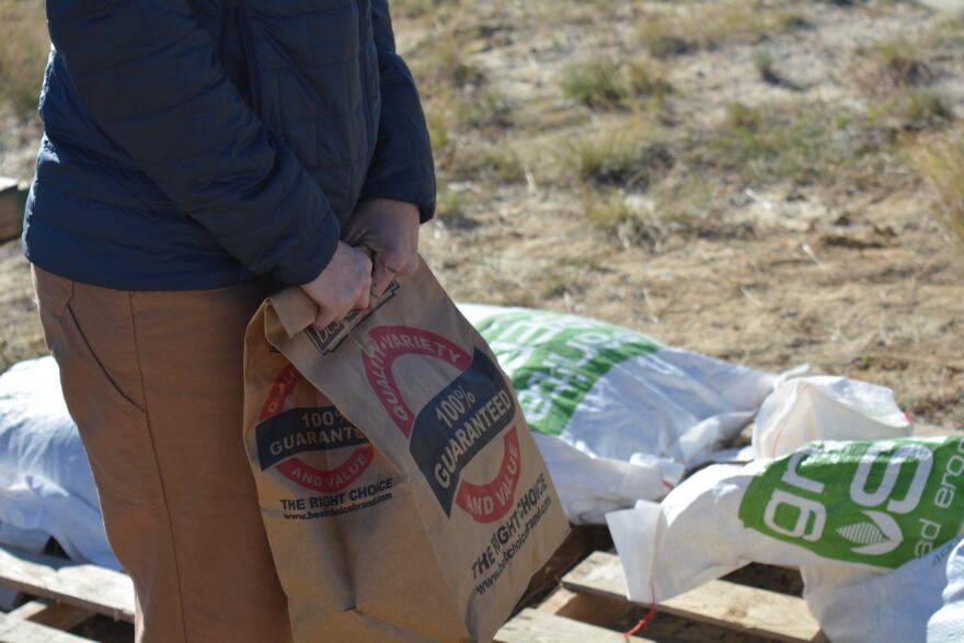 A woman holds a brown paper bag