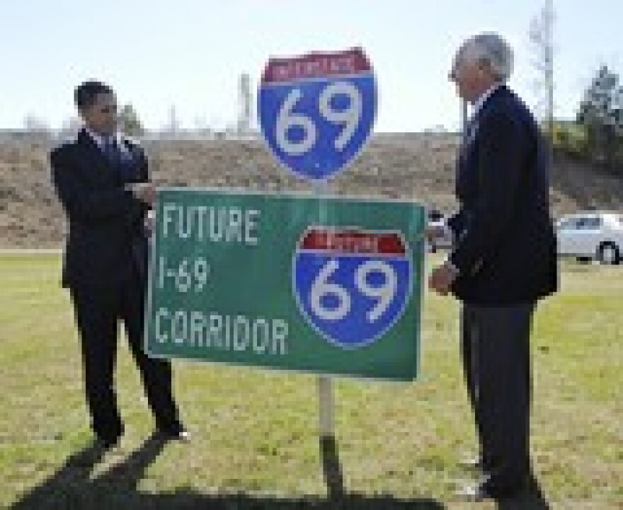 Kentucky Governor Steve Beshear, right, and Federal Highway Administration Administrator Victor Mendez, left, unveil the new Interstate 69 sign signaling a 38 mile section of the Western Kentucky Parkway to be designated as I-69 in Nortonville, Ky.