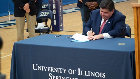 Gov. JB Pritzker signs legislation at the University of Illinois Springfield in 2021.