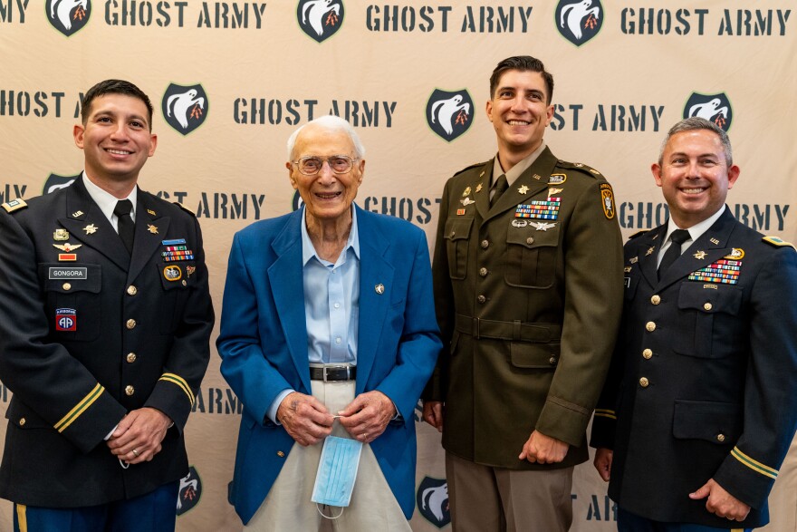 World War II "Ghost Army" veteran George Dramis of Raleigh poses with members of the modern day Army psychological operations unit in 2022.