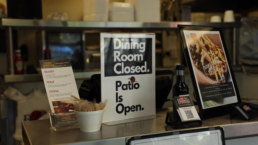 A sign at Off the Bone Barbeque explains that patio dining is available, though indoor dining is closed due to the pandemic.
