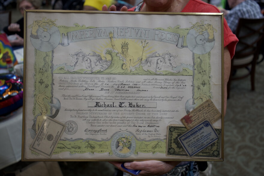Judi Baker shows fellow residents at Brookdale Senior Living her father's shellback certificate that is framed and usually hung in his room.