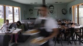 FILE - A waiter carries an order at Kao Bar & Grill in Hallandale Beach, Fla., July 10, 2023. Regional inflation in June 2025 was 3.1%, it's highest rate in a year.