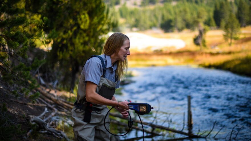 National Park Service hydrologist Erin White prepares to test the waters of the Firehole River near Yellowstone’s famous Old Faithful geyser.