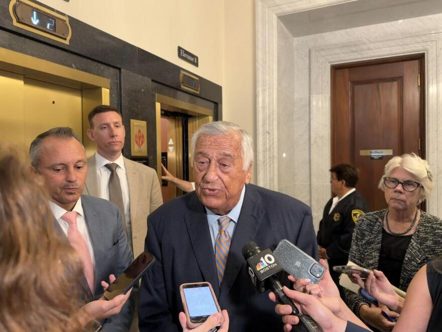 Mass. House Speaker Ron Mariano speaks to reporters at a scrum at the State House on July 30, 2026. House Ways and Means Chair Aaron Michlewitz is pictured on the left. Rep. Dan Cahill stands behind Mariano on the left, as does Rep. Alice Peisch on the right.