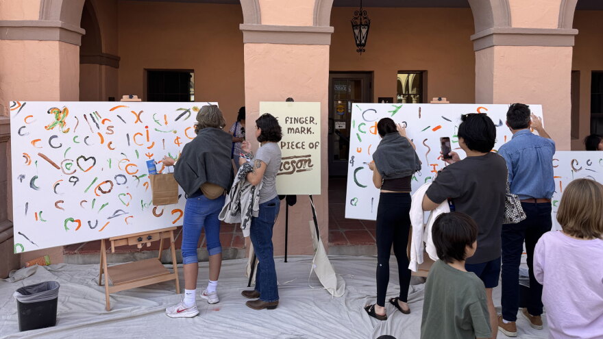 Visitors to Tucson Meet Yourself finger paint on canvases set up at the historic Pima County Courthouse on Oct. 17, 2026. 