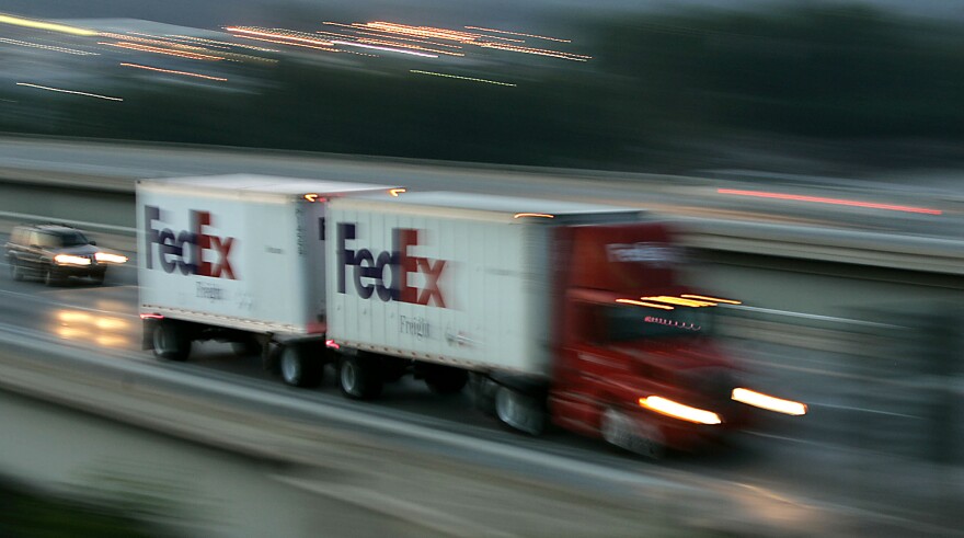A Federal Express delivery truck travels along a highway in Shawnee, Kan. Tuesday, June 21, 2005. FedEx Corp. said Thursday, June 23, 2005, its fiscal fourth-quarter earnings increased 9 percent from last year, but costs associated with the start-up of a new westbound, around-the-world flight kept the package deliverer's results below Wall Street expectations. (AP Photo/Charlie Riedel)