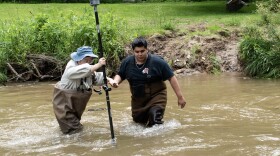 Uriel Vaca and QiFan Zhao measure the depth of a creek where they are building a bridge.