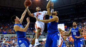 Florida's Kasey Hill (0) fights his way toward the basket, going up strong against Kentucky's Karl-Anthony Towns (12) and Devin Booker (1).