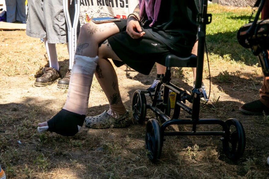 Emma Landis, a protester who was recently shot by a GEO Group employee working at U.S. Immigration and Customs Enforcement's Denver Contract Detention Facility in Aurora, speaks about her experience to a crowd gathered outside of the prison. July 19, 2026.