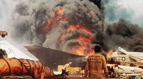 Navy crewmen try to put out a fire aboard the USS Forrestal in the Tonkin Gulf, off the coast of Vietnam, on July 29, 1967.