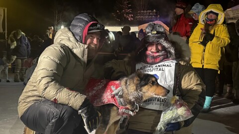 Yukon Quest Alaska 750 champion Josi Shelley poses with one of her lead dogs and husband J.J. after crossing the finish line Monday night at Pikes Landing in Fairbanks.