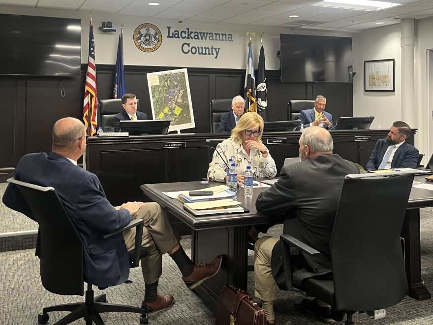 Lackawanna County Commissioner Bill Gaughan, left, holds up a map he had the county's land development office create of two proposed massive power plants for the county.