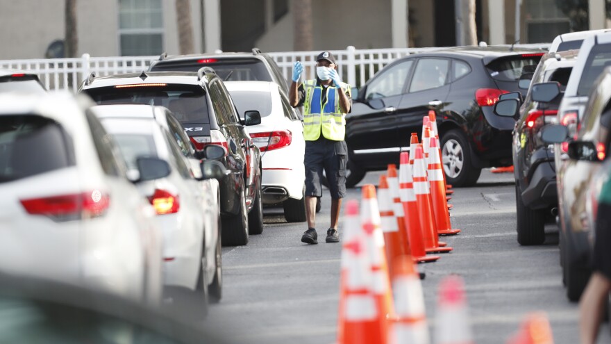 A public safety officer directs drivers where to go last week at a coronavirus testing site at the Lee Davis Community Resource Center in Tampa, Fla.