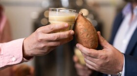 A glass of sweet potato milk displayed next to a sweet potato