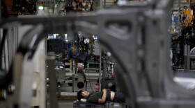 A worker takes a nap during a lunch break at the Chinese automaker BAIC SUV assembly plant in Beijing, Wednesday, Aug. 29, 2018. (Andy Wong/AP)