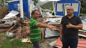 Jan Carlo Perez (right) talks with a neighbor this month in front of a house demolished in Patillas, Puerto Rico, by Hurricane Maria in September.
