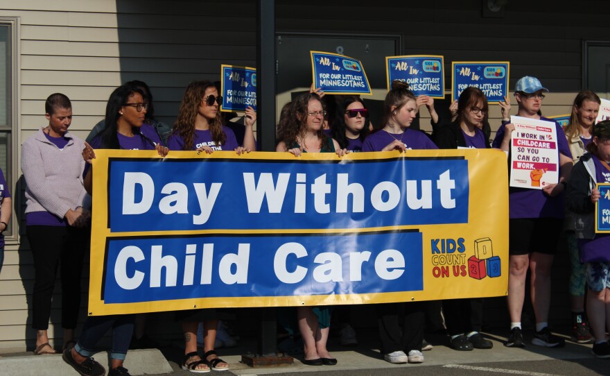 Early childhood care providers and educators hold a banner at a press conference at Iron Range Tykes Learning Center in Mountain Iron for national Day Without Child Care on May 13, 2024.